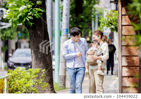 A couple walking with a child 104439022
