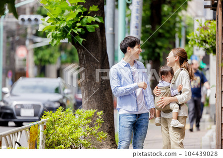 A couple walking with a child 104439028