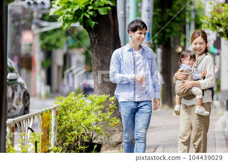 A couple walking with a child A couple walking with a child 104439029