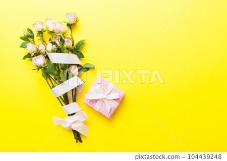 design concept with pink rose flower and gift box on colored table background top view. Happy Holiday, Mothers day, birthday concept. Romantic flat lay composition design concept with pink rose flower and gift box on colored table background top view. Happy Holiday, Mothers day, birthday concept. Romantic flat lay composition 104439248