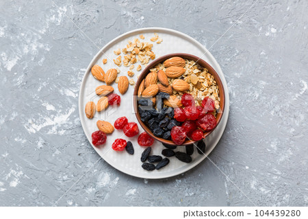 Cooking a wholesome breakfast. Granola with Various dried fruits and nuts in a bowl. The concept of a healthy dessert. Flat lay, top view with copy space 104439280