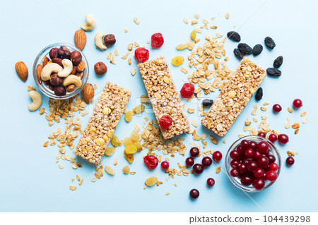Various granola bars on table background. Cereal granola bars. Superfood breakfast bars with oats, nuts and berries, close up. Superfood concept Various granola bars on table background. Cereal granola bars. Superfood breakfast bars with oats, nuts and berries, close up. Superfood concept 104439298