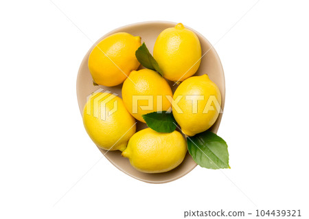 Fresh cutted lemon and whole lemons over round plate isolated on white background. Food and drink ingredients preparing. healthy eating theme top view with copy space Fresh cutted lemon and whole lemons over round plate isolated on white background. Food and drink ingredients preparing. healthy eating theme top view with copy space 104439321