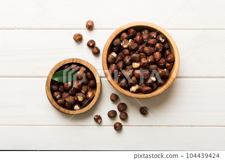 Wooden bowl full of hazelnuts on table background. Healthy eating concept. Super foods Wooden bowl full of hazelnuts on table background. Healthy eating concept. Super foods 104439424