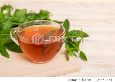 Cup of mint tea on table background. Green tea with fresh mint top view with copy space 104439451