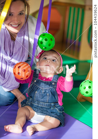 Beautiful ten months baby girl playing with her mom. Early stimulation for toddlers concept. Beautiful ten months baby girl playing with her mom. Early stimulation for toddlers concept. 104439624