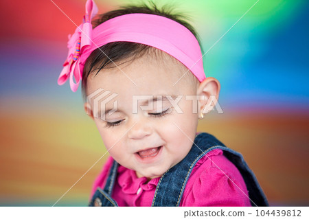 Portrait of a happy beautiful ten months baby girl on a colorful background. Early stimulation for toddlers concept. Portrait of a happy beautiful ten months baby girl on a colorful background. Early stimulation for toddlers concept. 104439812
