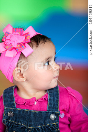 Portrait of a beautiful ten months baby girl on a colorful background. Early stimulation for toddlers concept. Portrait of a beautiful ten months baby girl on a colorful background. Early stimulation for toddlers concept. 104439813