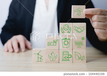 Hand of a businessman chooses reduce co2 icon on wood block circle.idea for environmentally conscious business, climate change, eco-friendly investment,ESG for Environment Social and Governance 104440199