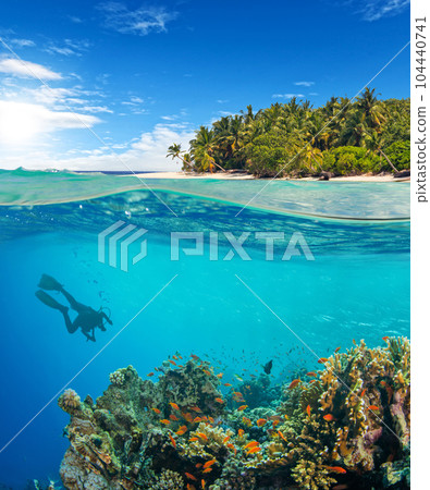 Under and above water surface view of scuba diver 104440741