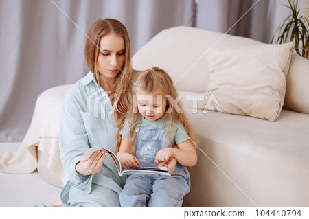 Mom and little daughter in blue pajamas are hugging 104440794