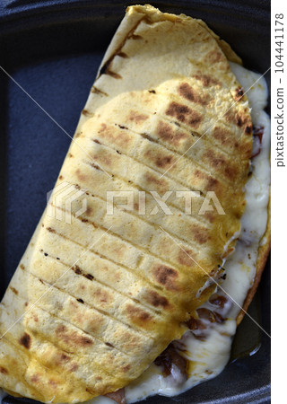 Delicious Burrito. Pie with meat and cheese. A hearty breakfast. 104441178