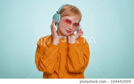 Happy woman in headphones listening music dancing disco having fun relaxing on christmas party 104442009