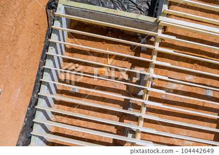 New custom home installation of wood floor joists trusses on concrete block foundation New custom home installation of wood floor joists trusses on concrete block foundation 104442649
