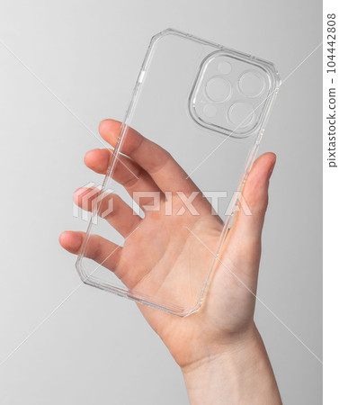 Hand holding mobile phone case, transparent smartphone protection 104442808