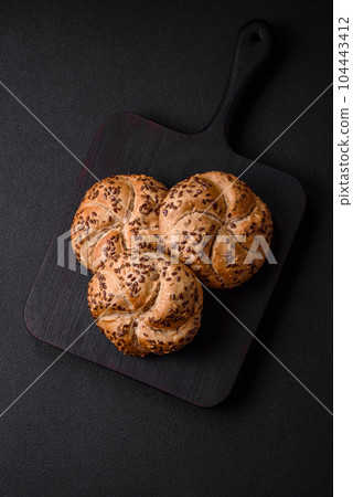 Delicious freshly baked crispy bun or kaiser roll with sesame seeds Delicious freshly baked crispy bun or kaiser roll with sesame seeds 104443412