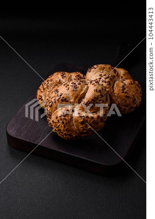 Delicious freshly baked crispy bun or kaiser roll with sesame seeds 104443413
