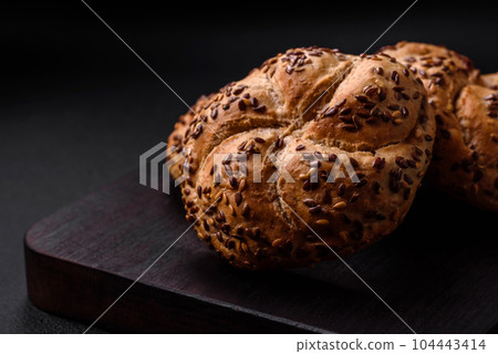 Delicious freshly baked crispy bun or kaiser roll with sesame seeds 104443414