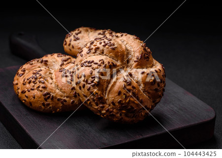 Delicious freshly baked crispy bun or kaiser roll with sesame seeds Delicious freshly baked crispy bun or kaiser roll with sesame seeds 104443425