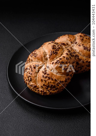 Delicious freshly baked crispy bun or kaiser roll with sesame seeds Delicious freshly baked crispy bun or kaiser roll with sesame seeds 104443431