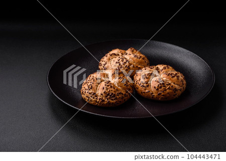 Delicious freshly baked crispy bun or kaiser roll with sesame seeds 104443471