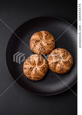 Delicious freshly baked crispy bun or kaiser roll with sesame seeds Delicious freshly baked crispy bun or kaiser roll with sesame seeds 104443474