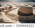 Wicker straw hat on beach sand. Summer sea vacation concept 104444222