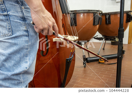 Real life young music students during rehearsals. Musical instruments and music stand with stave. Real life young music students during rehearsals. Musical instruments and music stand with stave. 104444228