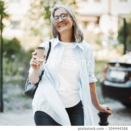 Woman in good mood, radiating happiness and contentment with life. The image features lady standing on a street, exuding joyful and carefree demeanor. . High quality photo Woman in good mood, radiating happiness and contentment with life. The image features lady standing on a street, exuding joyful and carefree demeanor. . High quality photo 104444386