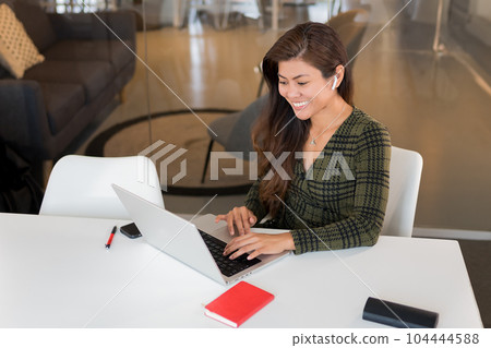 Content Asian worker with laptop in office 104444588