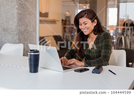 Smiling woman working on laptop Smiling woman working on laptop 104444599