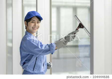 穿著工作服清潔窗戶的女人 穿著工作服清潔窗戶的女人 104444686