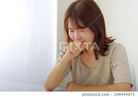 一個女人用手摀著嘴,表情痛苦 一個女人用手摀著嘴,表情痛苦 104444973