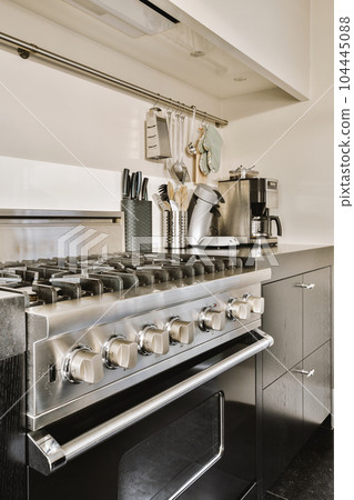 a kitchen with an oven, stove and coffee pots on the counter area in front of the stovetop 104445088