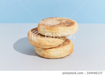 Bolo de caco. Traditional portuguese bread on blue creative background in minimal style Bolo de caco. Traditional portuguese bread on blue creative background in minimal style 104446137