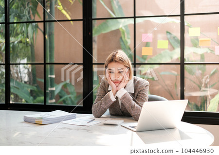 Asian woman working in the beautiful office with coffee computer and mobile phone. Asian woman working in the beautiful office with coffee computer and mobile phone. 104446930