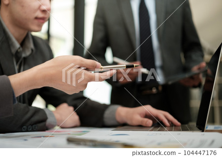Close up group of business men and woman discussion and brainstorming, bookkeeping audit graph and chart documents at desk, teamwork concept. 104447176
