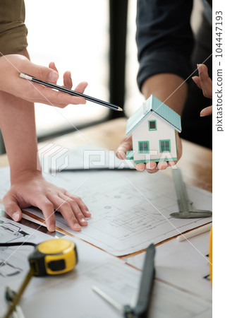 Engineers consulting team close up to design building blueprints paper for clients with building models to work at office. Engineers consulting team close up to design building blueprints paper for clients with building models to work at office. 104447193
