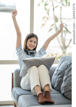 Beautiful Asian women feel relaxed on the weekends. She was sitting on a comfortable sofa at home. look at camera. Beautiful Asian women feel relaxed on the weekends. She was sitting on a comfortable sofa at home. look at camera. 104447274