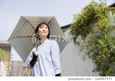 Photo of a woman holding a parasol Photo of a woman holding a parasol 104447477