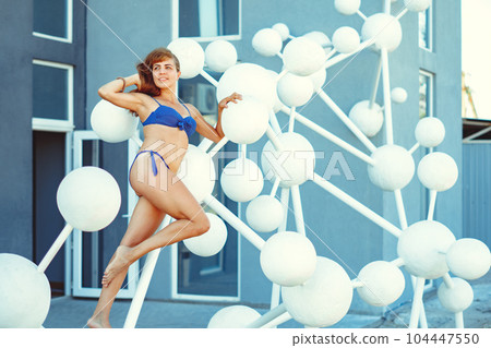 a girl in a swimsuit poses with plastic balls a girl in a swimsuit poses with plastic balls 104447550