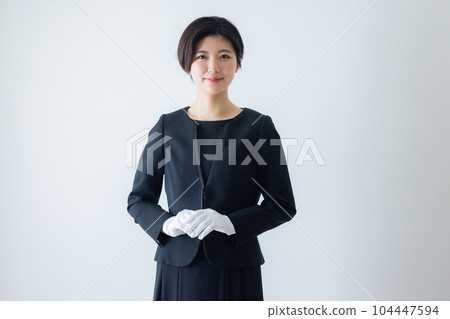 一個穿著黑色西裝、戴著白手套的女人 104447594