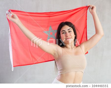 Young woman with flag of Morocco posing in studio Young woman with flag of Morocco posing in studio 104448331