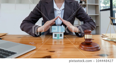 Beautiful Asian woman lawyer work on real estate loan contract example home of a mallet with a laptop placed at the office Beautiful Asian woman lawyer work on real estate loan contract example home of a mallet with a laptop placed at the office 104448427