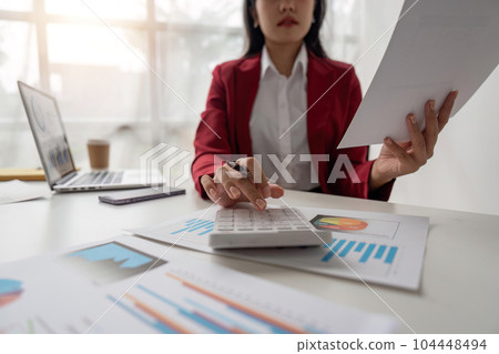 Close-up of businesswoman hands using a calculator to check company finances and earnings and budget. Business woman calculating monthly expenses, managing budget, papers, loan documents, invoices Close-up of businesswoman hands using a calculator to check company finances and earnings and budget. Business woman calculating monthly expenses, managing budget, papers, loan documents, invoices 104448494