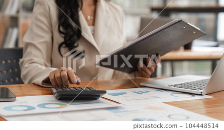 Accountant or business woman working Financial investment on calculator, calculate, analyze business and marketing growth on financial document data graph Accountant or business woman working Financial investment on calculator, calculate, analyze business and marketing growth on financial document data graph 104448514