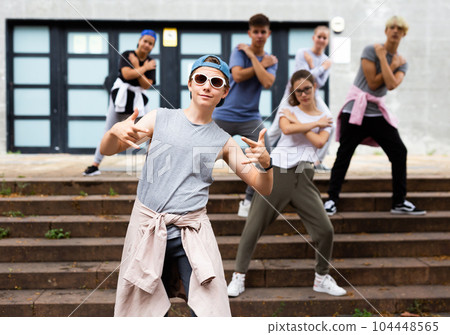 Teen boy dancing modern street dance with teenagers Teen boy dancing modern street dance with teenagers 104448565
