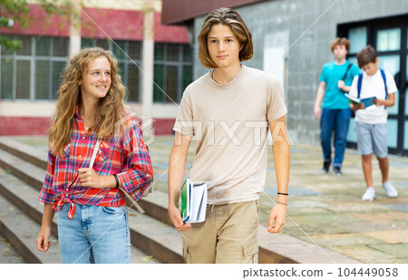 Boy and girl walking home after finishing lessons Boy and girl walking home after finishing lessons 104449058