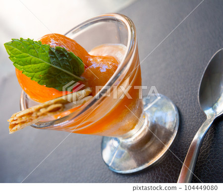 Sweet tasty orange ice-cream, served with wafer and mint on cup 104449080