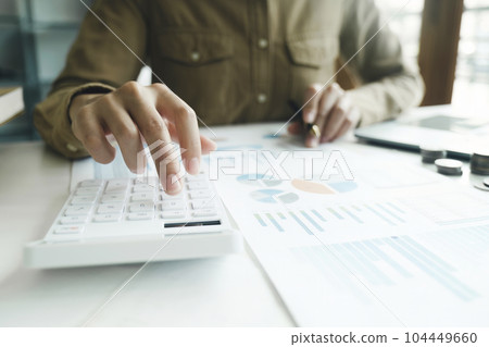 Accountant using calculator for calculate finance report in office 104449660